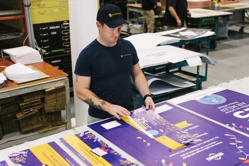 Man sorting newly printed branded assets